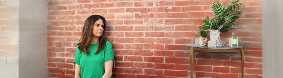 A woman sitting in quiet reflection, symbolizing the emotional impact of female orgasmic disorder and the journey toward treatment.