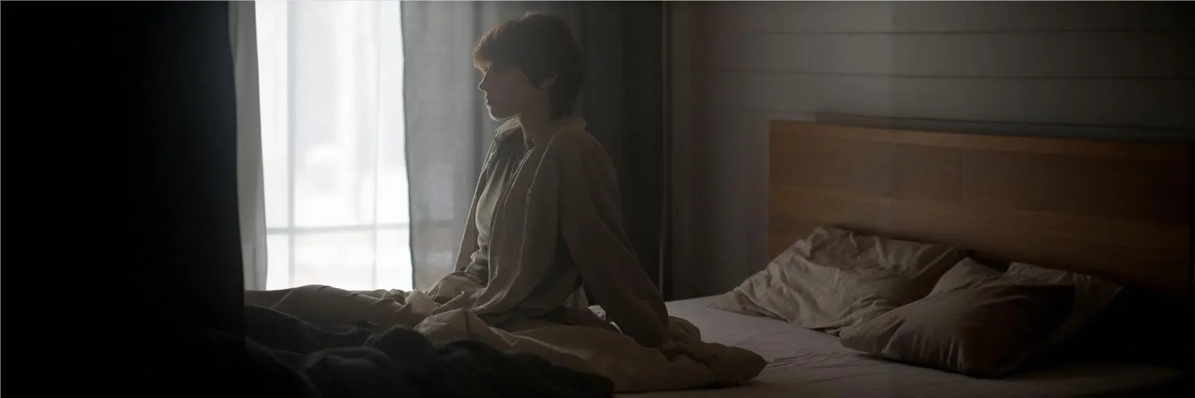 A person sitting alone in a dimly lit room, symbolizing the struggles of persistent depressive disorder and chronic depression.