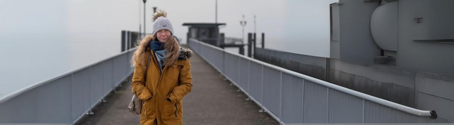A woman sitting by a light therapy lamp, addressing symptoms of seasonal affective disorder during winter.