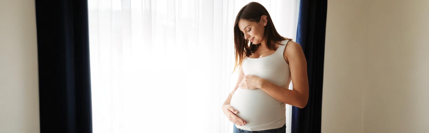 Pregnant woman in a hospital bed discussing labor induction options for gestational diabetes with a doctor.